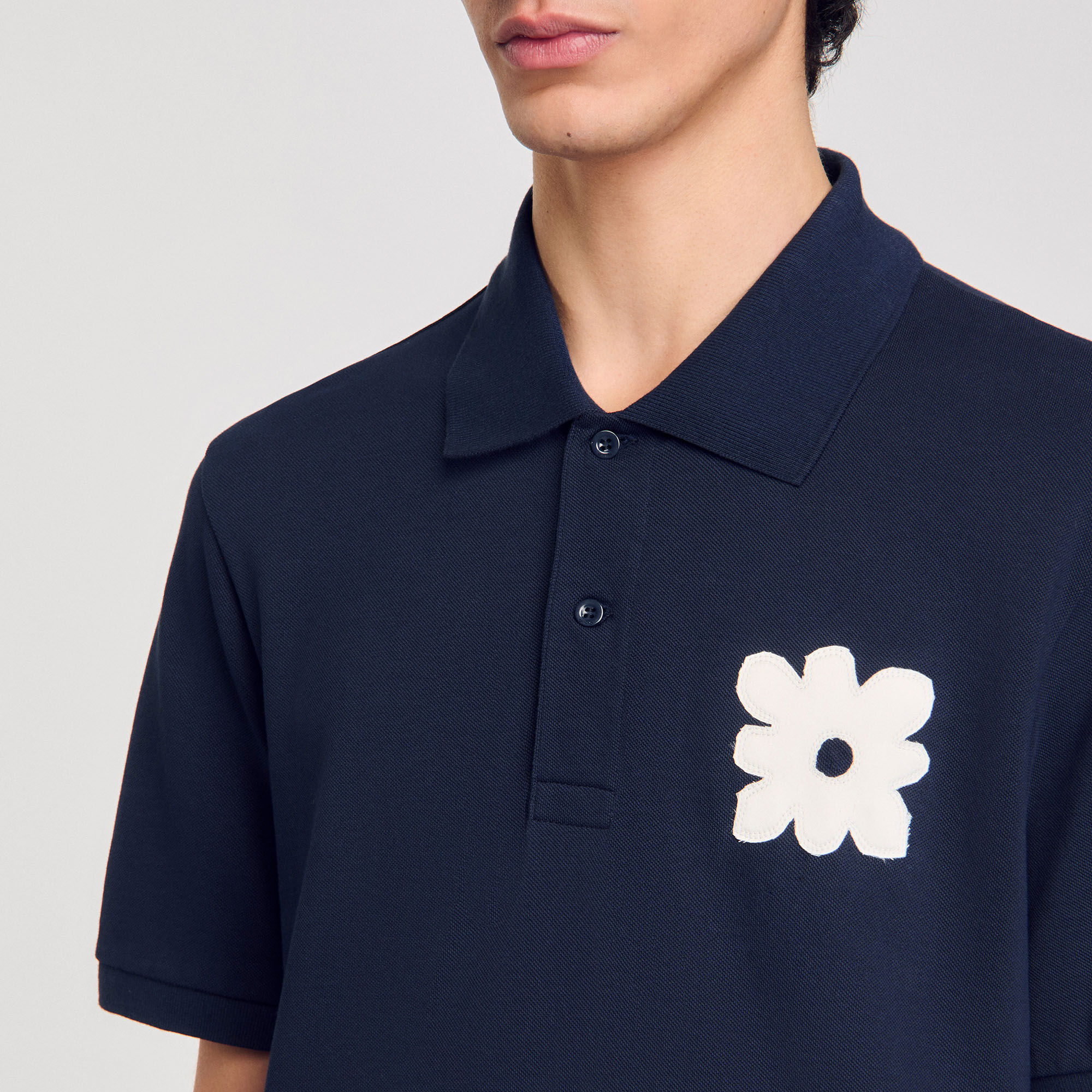 Polo con parche de flor