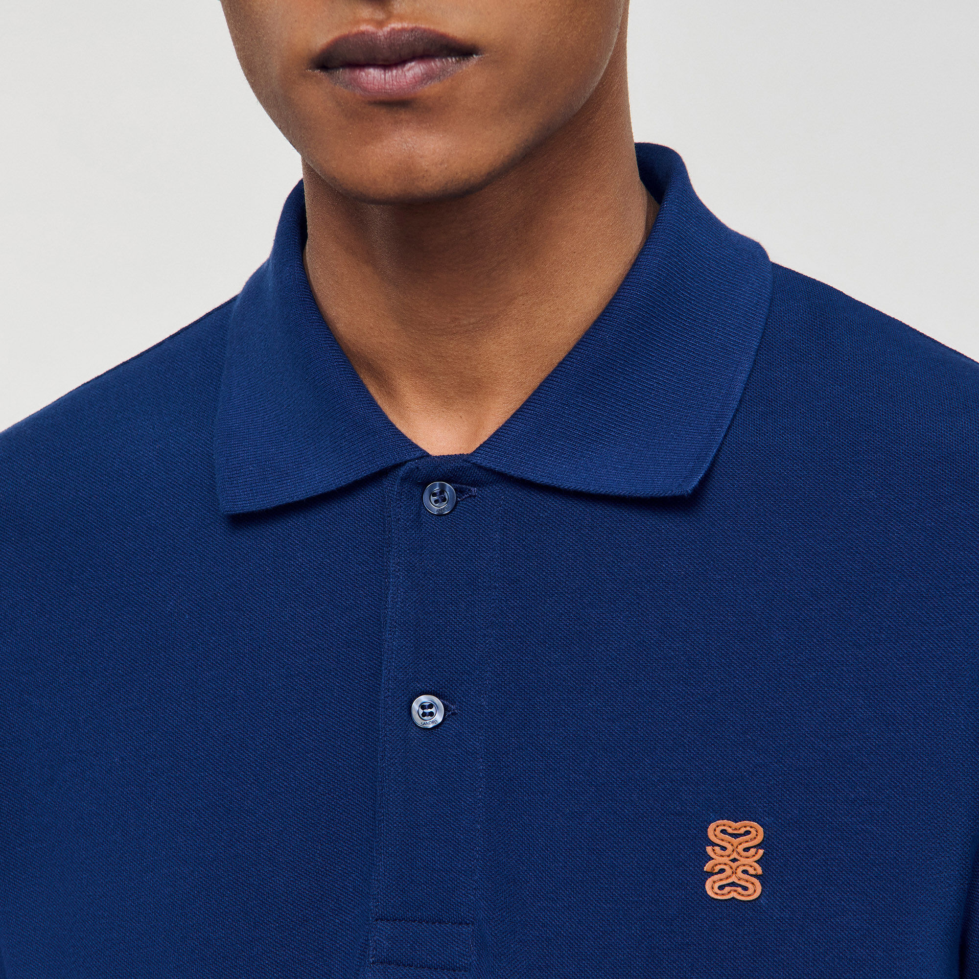 Polo con logotipo de cuero